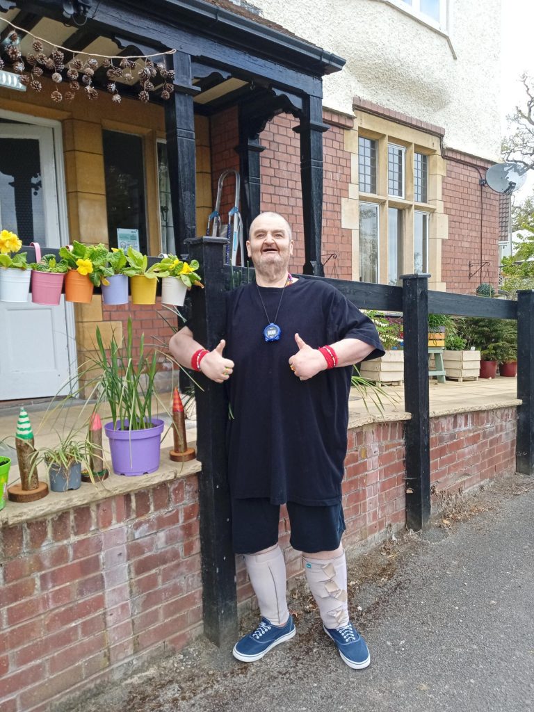 David can be seen smiling outside Cote House Residential Nursing Care home after a successful long distance walk.